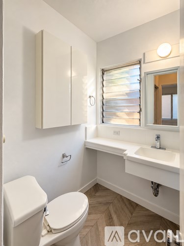 A white toilet sits next to a sink in a small bathroom.