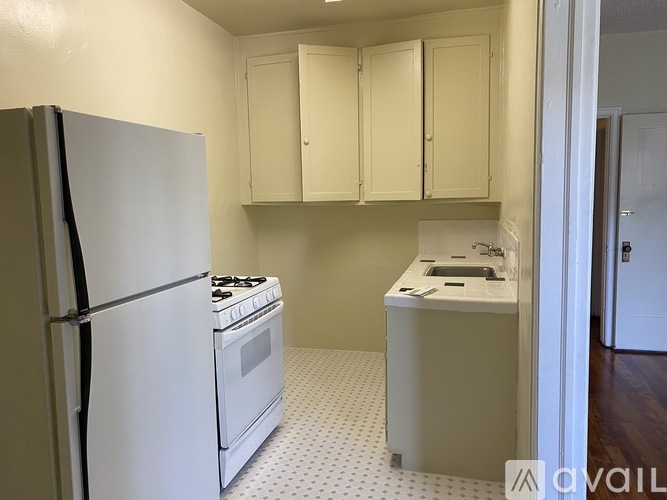 A kitchen with a white refrigerator, white stove, and white cabinets.
