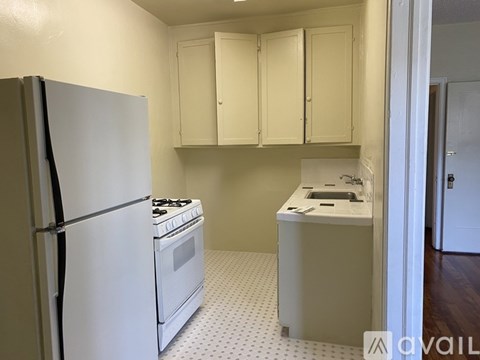 A kitchen with a white refrigerator, white stove, and white cabinets.