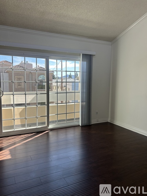 A room with a sliding glass door leading to a balcony.