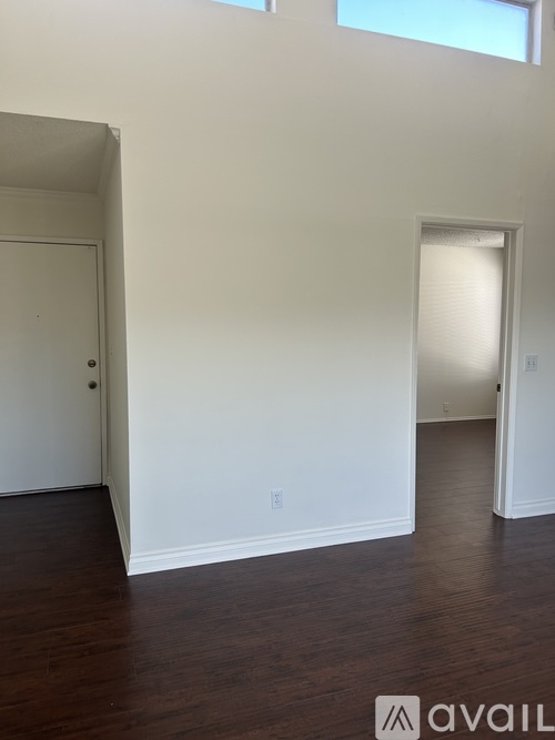 A room with white walls and wooden floors.