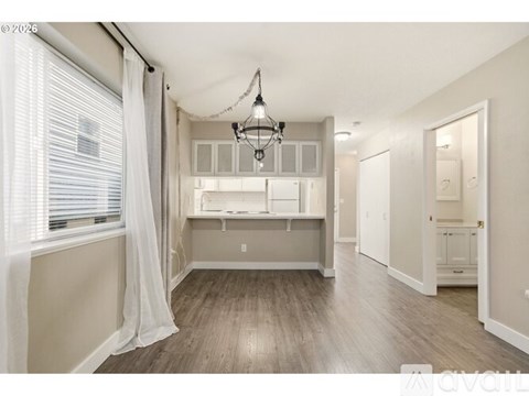 A well-lit, spacious kitchen area with a dining table and chairs.