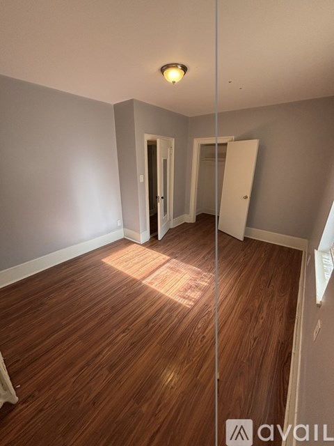A room with wooden flooring and a white door.