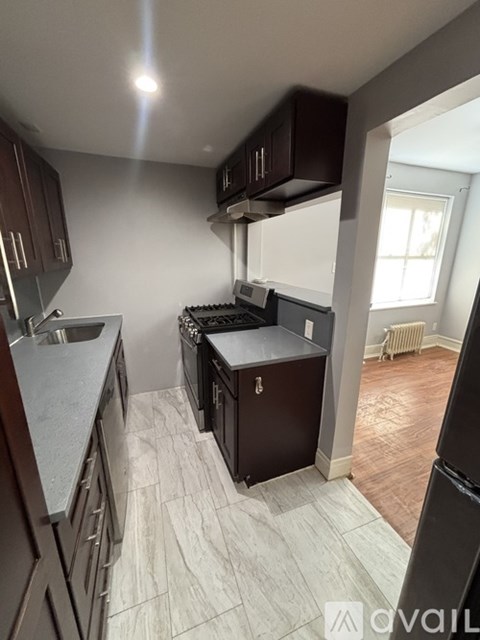 A kitchen with dark wood cabinets and a white countertop.