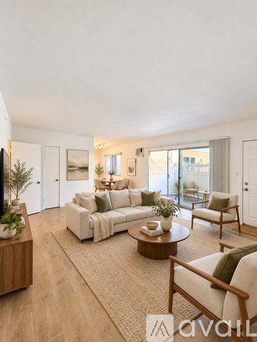 A living room with a white couch, a coffee table, and a TV on the left side.