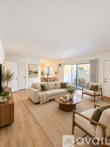 A living room with a white couch, a coffee table, and a TV on the left side.