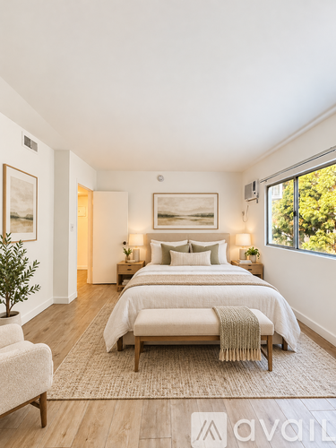 A bedroom with a large bed and a chair.