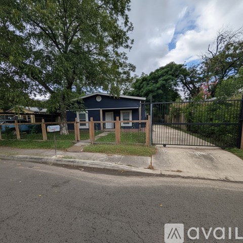 A blue building with a white sign in front of a black fence.