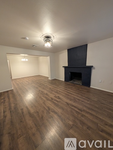 A room with wooden flooring and a fireplace.