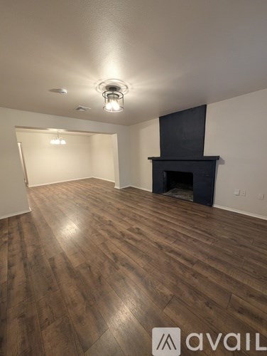 A room with wooden flooring and a fireplace.