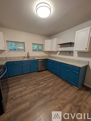 A kitchen with blue cabinets and wooden floors.