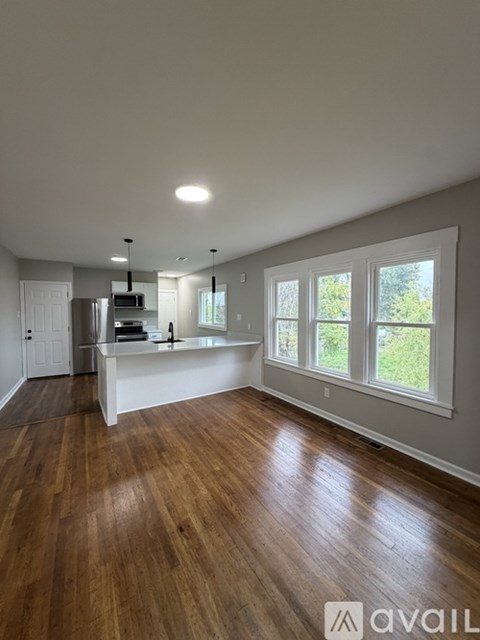 A spacious room with wooden floors and white walls.