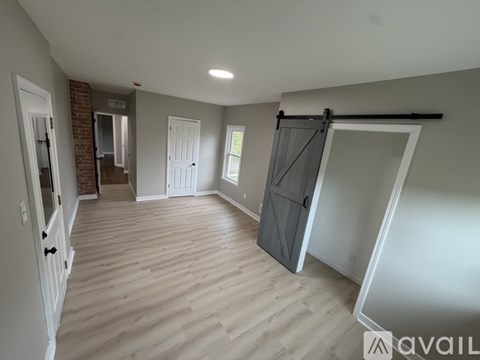 A room with a sliding door and a brick wall.