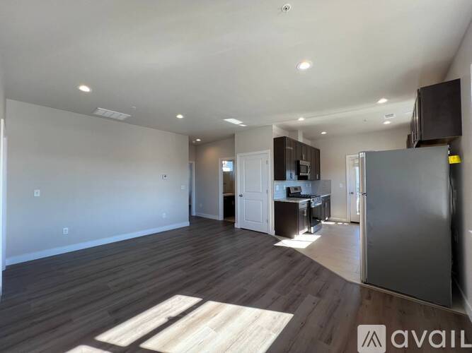 A spacious living area with a kitchen in the background.