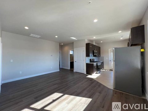 A spacious living area with a kitchen in the background.