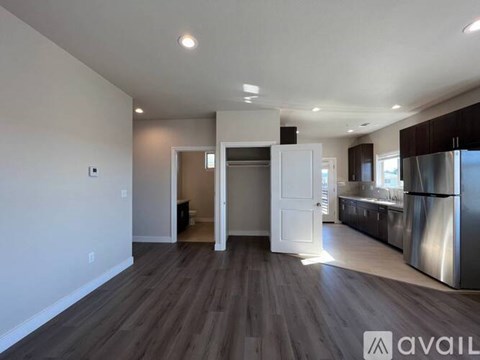 A spacious kitchen with stainless steel appliances and a wooden floor.