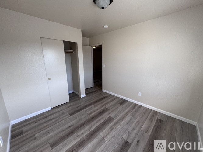 A room with wooden flooring and a white door.