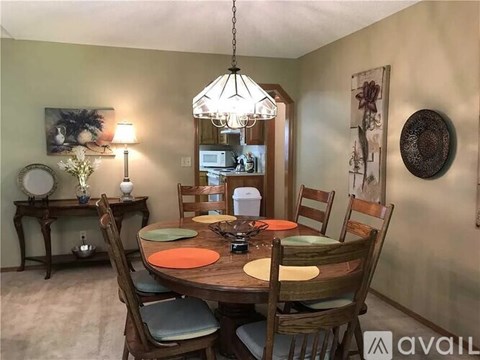A dining room with a wooden table and chairs.
