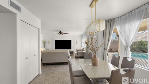 A modern living room with a white dining table and grey chairs.