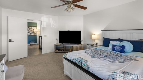 A bedroom with a large bed and a flat screen TV.