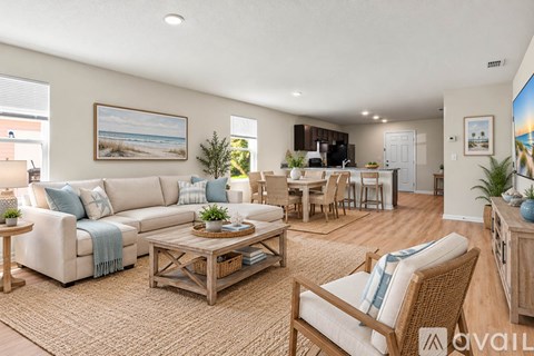 A living room with a white couch, wooden coffee table, and a painting of a beach scene on the wall.
