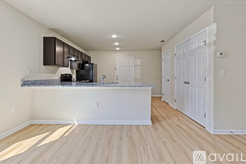 A kitchen with white cabinets and a black fridge.