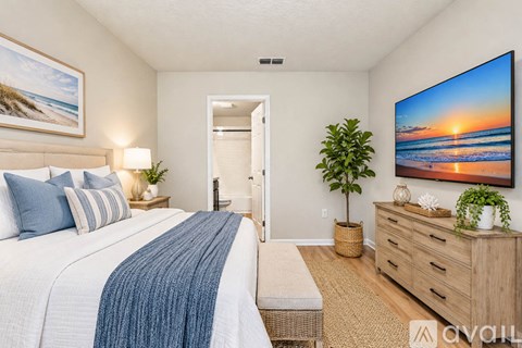 A bedroom with a large bed and a painting on the wall.