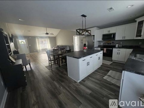 A kitchen with a black countertop and white cabinets.