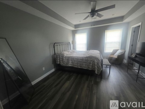 A bedroom with a bed, a chair, and a desk.