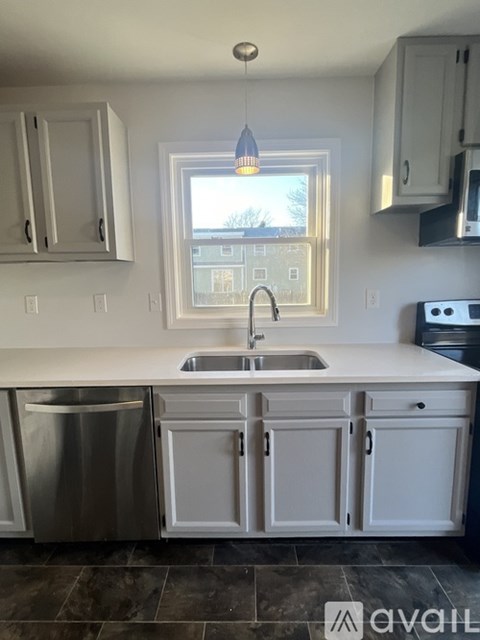 A kitchen with white cabinets and a window.