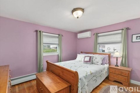 A bedroom with a bed, nightstand, and window.
