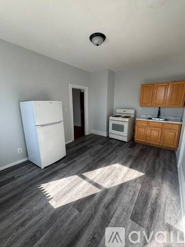 A kitchen with a white fridge and wooden cabinets.