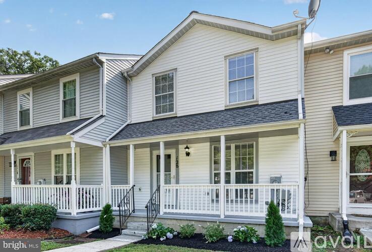 A two-story house with a front porch and a garage door.