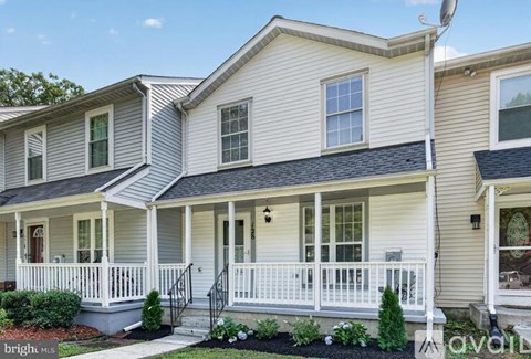 A two-story house with a front porch and a garage door.