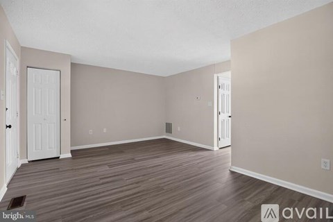 A room with wooden flooring and white doors.