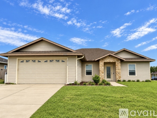 A house with a garage and a driveway in front.