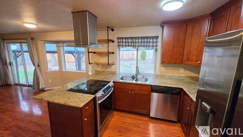 A kitchen with wooden cabinets and a granite countertop.