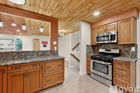 A kitchen with wooden cabinets and granite countertops.