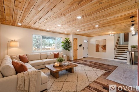 A living room with a white couch and a wooden ceiling.