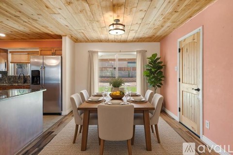 A dining room with a wooden table and chairs.