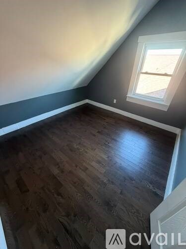 A room with wooden flooring and a window.