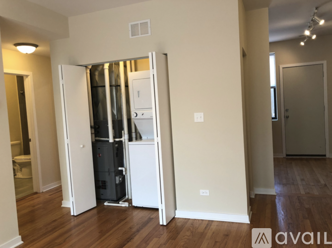 A room with a white fridge and a white freezer with a white door open.