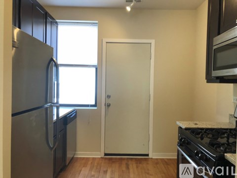 A kitchen with a refrigerator, oven, and microwave.