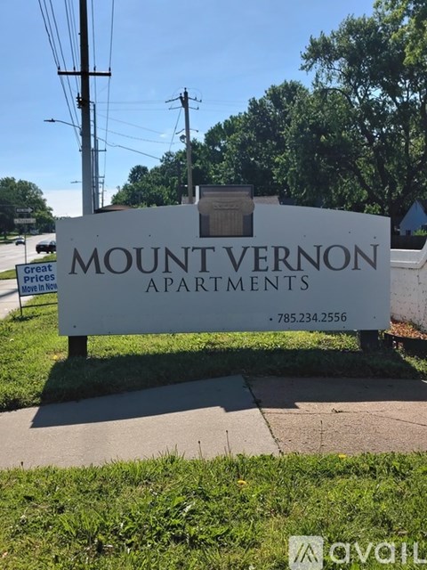A sign for Mount Vernon Apartments is displayed in front of a grassy area.
