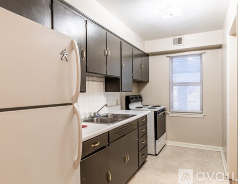 A kitchen with a white refrigerator and black cabinets.