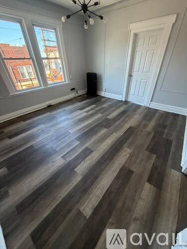 A room with wooden flooring and a ceiling fan.