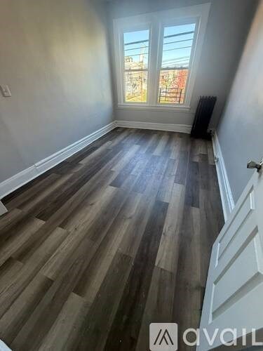 A room with wooden flooring and a window.