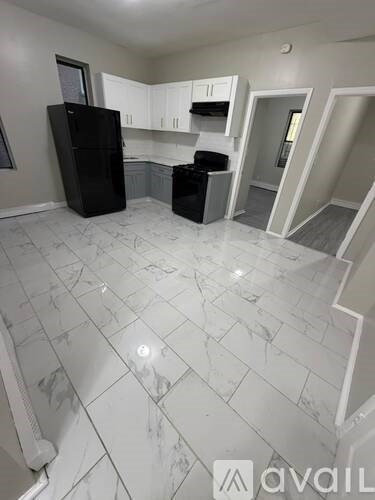 A kitchen with a black fridge and a white counter top.