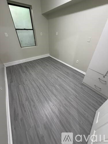 A room with a grey floor and a window.