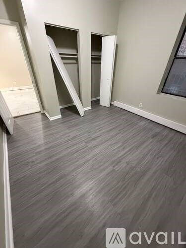 A room with a grey floor and a wall with a window.